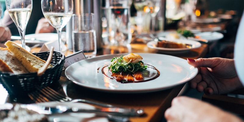 A plated lunch at a chef's table, a hand reaching for the dish