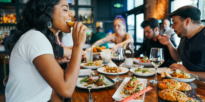Friends passing plates along a communal table
